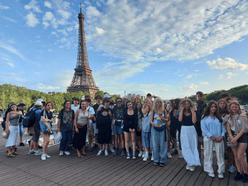 Zdjęcie grupowe uczniów z widokiem na wieżę Eiffla - wycieczka ATAS